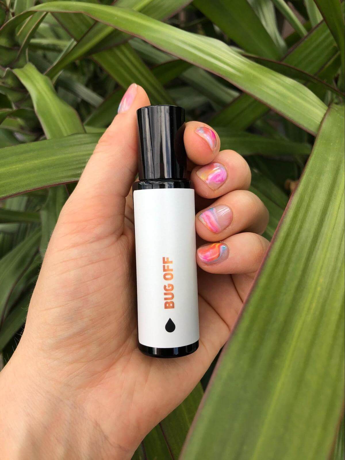 Person holding a bottle of essential oils for bug bites